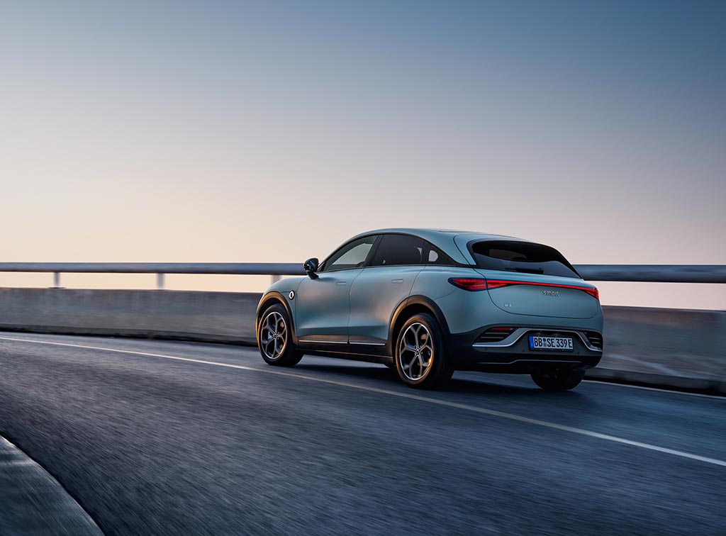 Rear view of a light blue smart #3 electric car driving on a bridge overpass