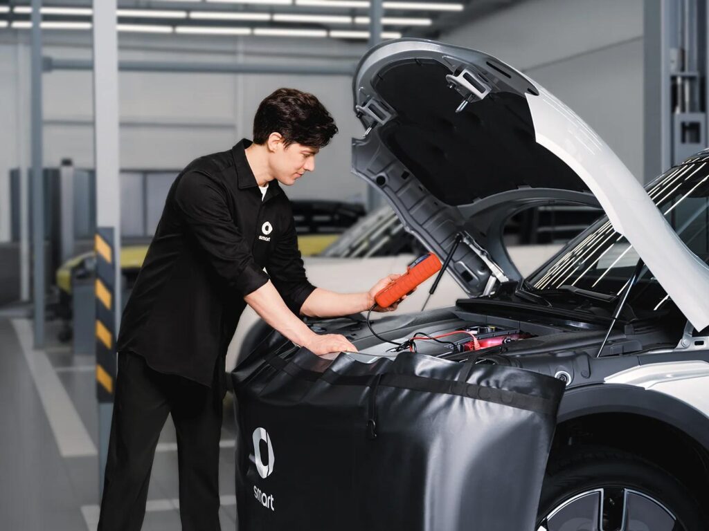 Service technician servicing a smart electric car in a dealership workshop