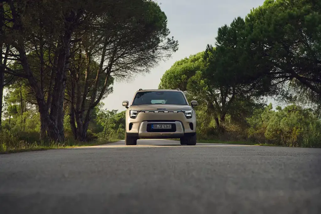 Front view of a smart #5 electric SUV driving on a tree-lined country road